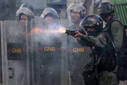 Un miembros de la Guardia Nacional Bolivariana dispara contra los manifestantes opositores.