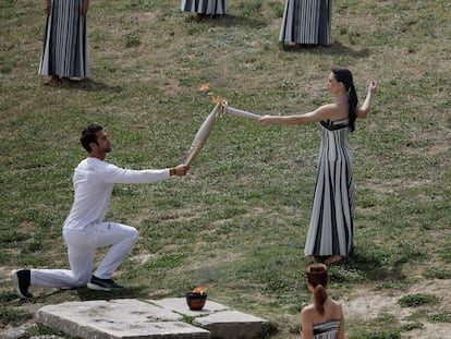 La actriz griega Mary Mina, en su rol de sacerdotisa, pasa la llama olímpica al primer relevista, el piraguista griego Stefanos Ntouskos, durante la ceremonia de encendido este martes.