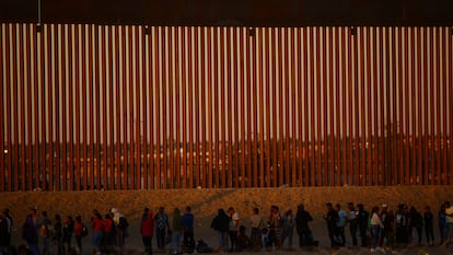 Migrants seeking asylum in the United States gather near a border wall on the banks of the Rio Bravo, on the border between the U.S. and Mexico, on Sept. 19, 2023.