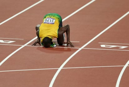 Usain Bolt besa la pista de atletismo.