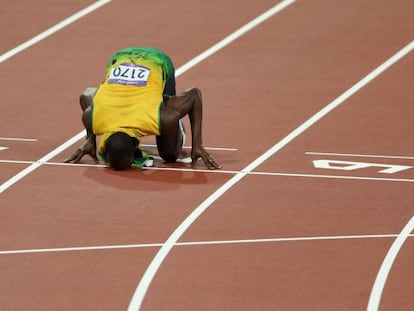 Usain Bolt besa la pista de atletismo.