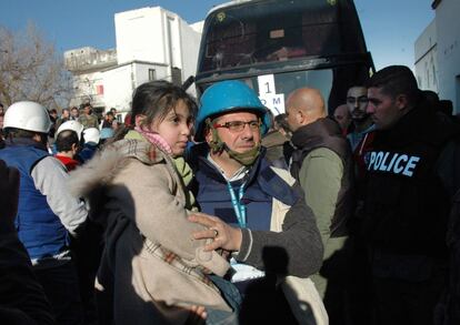 La ayuda humanitaria llega a las zonas controladas por los rebeldes en la ciudad siria de Homs donde los civiles están siendo evacuados. Un trabajdor de la ONU lleva a una niña en brazos.