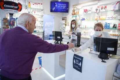 Un cliente mantiene la distancia de seguridad mientras es atendido en una farmacia del centro de Madrid.
