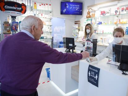 Un cliente mantiene la distancia de seguridad mientras es atendido en una farmacia del centro de Madrid.