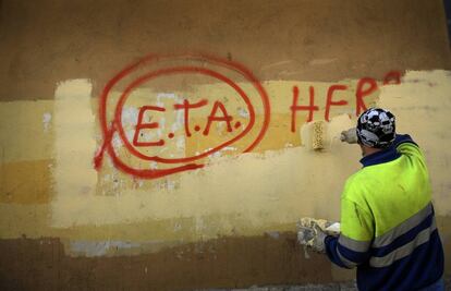 Un trabajador municipal borrando una pintada en la pared