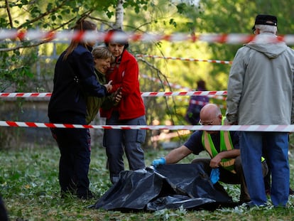 Una mujer llora cerca del cadáver de su hija, muerta en el ataque ruso contra Kiev de este jueves.