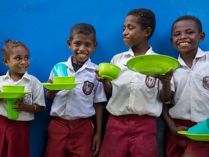 Un grupo de estudiantes esperan a entrar al comedor de su escuela.