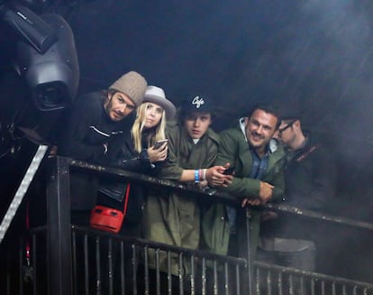 David Beckham, con gorro de lana, y su hijo Brooklyn, con gorra, acompañados de dos amigos viendo a Foo Fighters en Glastonbury.