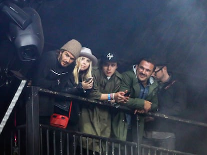 David Beckham, con gorro de lana, y su hijo Brooklyn, con gorra, acompañados de dos amigos viendo a Foo Fighters en Glastonbury.