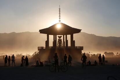 Participantes al festival observan el atardecer sobre "El hombre".