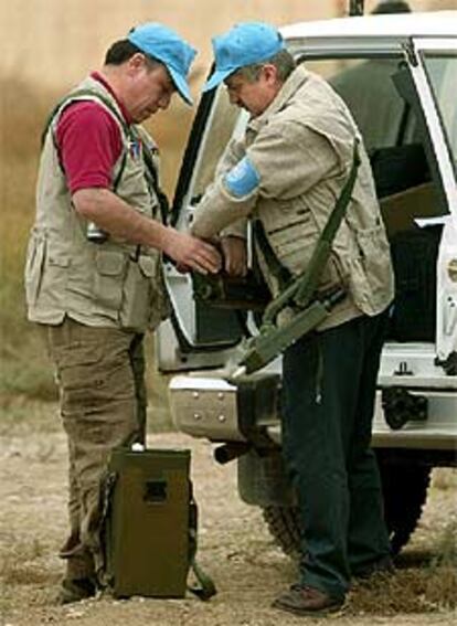 Dos inspectores preparan su euipamiento antes de partir hacia Yusufiya.