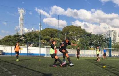 Ana Julia disputa a bola com um colega de equipe.