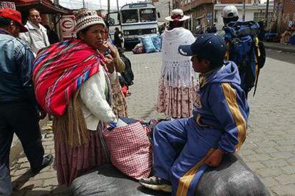 Varios bolivianos esperaban ayer un autobús que les llevara a El Alto en medio de la huelga de transporte público.