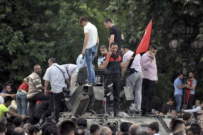 Un policía turco y un grupo de personas toman un vehículo militar en Ankara.