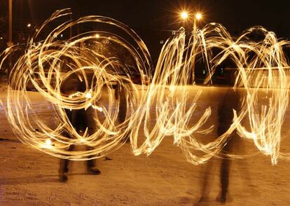 En las festividades a lo largo del planeta, especialmente en Asia, ha estado muy presente el fuego. En la imagen, dos personas realizan figuras con antorchas en la ciudad rusa de Krasnoyarsk, Siberia.