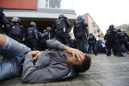 A man falls to the floor during an operation by Spanish National Police riot officers at the Mediterránea de la Barceloneta school, Barcelona.