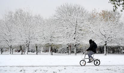 Un ciclista circula por un parque del centro de Londres totalmente cubierto de nieve. 