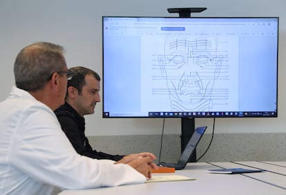 El inspector Sergio Castro examina junto a un compañero de la Policía Científica de Madrid un documento en el que se destacan rasgos clave del rostro para la identificación de individuos.