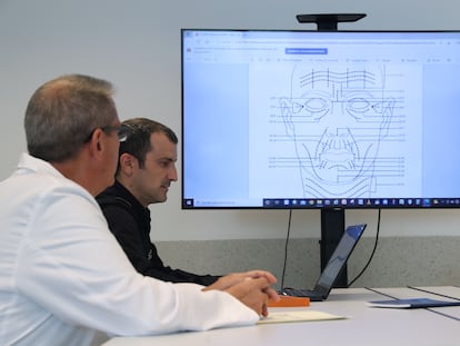 El inspector Sergio Castro examina junto a un compañero de la Policía Científica de Madrid un documento en el que se destacan rasgos clave del rostro para la identificación de individuos.