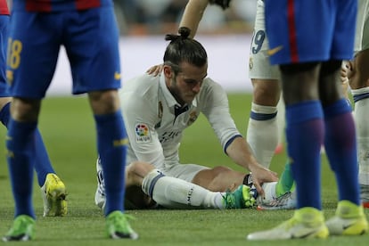 La cara de preocupación de Bale sentado en el césped del Bernabéu.