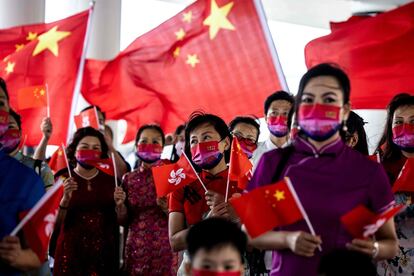 Un grupo de mujeres sostiene las banderas de Hong Kong y China, en Hong Kong, este viernes. El jefe de Estado, Xi Jinping, que viajó a Hong Kong acompañado de su esposa, Peng Liyuan, declaró el éxito del principio 'Un País, Dos Sistemas'. Con una precisión: un éxito bajo la “jurisdicción completa” de China.
