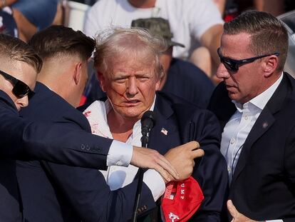 Donald Trump, rodeado por agentes del Servicio Secreto tras sufrir el atentado.