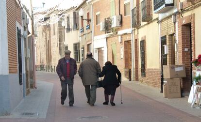 Tres personas pasean por la calle Mayor de Almedina.