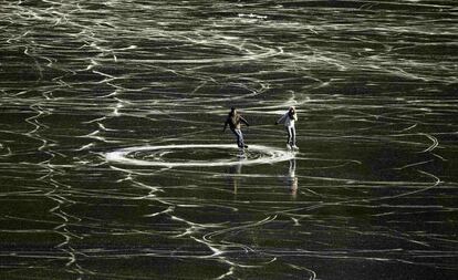 Una pareja patina sobre las aguas congeladas del lago St. Moritz en Suiza. 