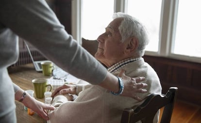 Una mujer atiende a un anciano.