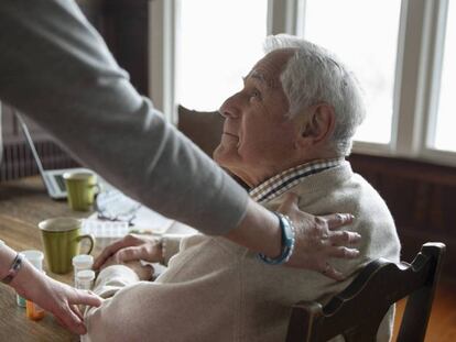 Una mujer atiende a un anciano.