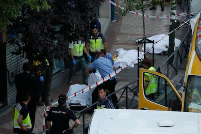 Los policías retiran los cuerpos de las tres víctimas asesinadas en el despacho de Víctor Salas, en la calle Marcelo Usera 40, Madrid, la tarde del 22 de junio de 2016.
