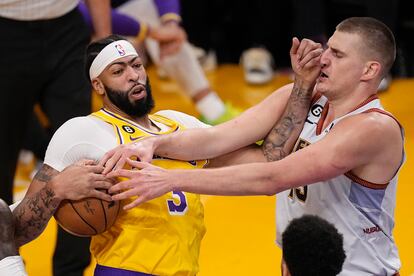 El alero de los Lakers, Anthony Davis, atrapa un rebote frente a la estrella de los Nuggets, Nikola Jokic.