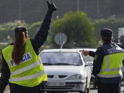 Varios agentes de Policía Nacional dan el alto a un vehículo en un control de movilidad en la parroquia de O Castiñeiriño (Santiago de Compostela), en la entrada y salida Santiago hacia Ourense