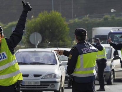 Varios agentes de Policía Nacional dan el alto a un vehículo en un control de movilidad en la parroquia de O Castiñeiriño (Santiago de Compostela), en la entrada y salida Santiago hacia Ourense