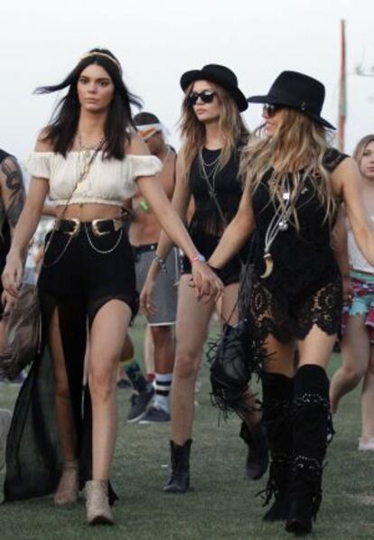 La modelo Kendall Jenner coge de la mano a la cantante Fergie y, al fondo, Hailey Baldwin cruzan el llamado campo de Polo de Coachella (Indio, California).