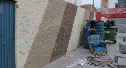 Trastos abandonados junto a los contenedores en uno de los solares del barrio del Cabanyal.
