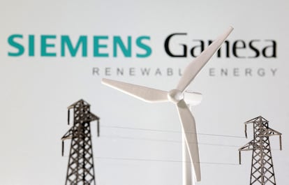 El logo de Siemens Gamesa, junto a un aerogenerador y dos torres eléctricas, en una ilustración.