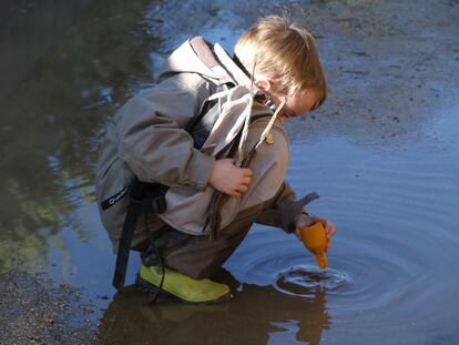 Un alumno del Grupo de Juego en la Naturaleza Saltamontes, de Collado Mediano, experimenta en un charco en su escuela en la naturaleza.