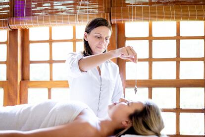 Mujer practica Reiki en una paciente.