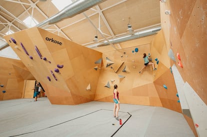 Dos personas escalan en Arkose, un rocódromo con coworking y cantina, abierto recientemente en Cuatro Caminos, Madrid. Imagen cedida.