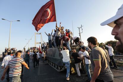 Varios ciudadanos ondean banderas y celebran el fracaso del golpe sobre un tanque del Ejército, en el puente del Bósforo de Estambul.