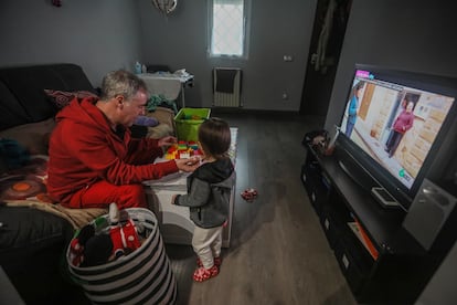 Un padre cuidando de su hija de dos años en su domicilio.