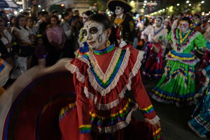 El diseño original es el de una calavera con un elegante y floreado sombrero sobre su cabeza. Con el paso de los años, la imagen de la Catrina se ha diversificado para incorporar diferentes elementos de la cultura mexicana. En la imagen, una mujer vestida de adelita y con la cara pintada de Catrina, durante la Megaprocesión de este domingo.