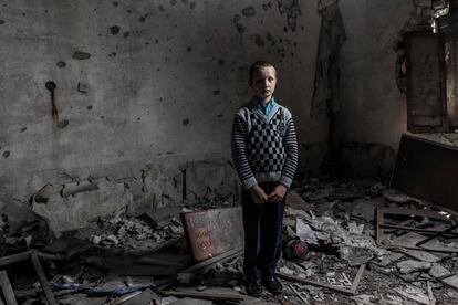 Yura Khromchenko, de nueve años, posa en un aula de infantil destruida por una bomba el pasado septiembre en la región de Luhansk (Ucrania). 
