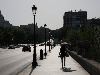 Una mujer se protege del sol con un paraguas este jueves, durante la ola de calor en Madrid.