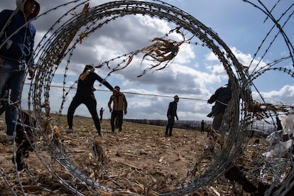 Migrantes intentan saltar la valla fronteriza en el paso turco de Pazarkule border crossing with Greece's Kastanies.