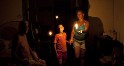 La gente se alumbra con velas durante el apagón.