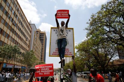 Un partidario del presidente keniano Uhuru Kenyatta muestra una pancarta frente a la Corte Suprema en protesta por la anulación de la victoria de Kenyatta, en Nairobi.