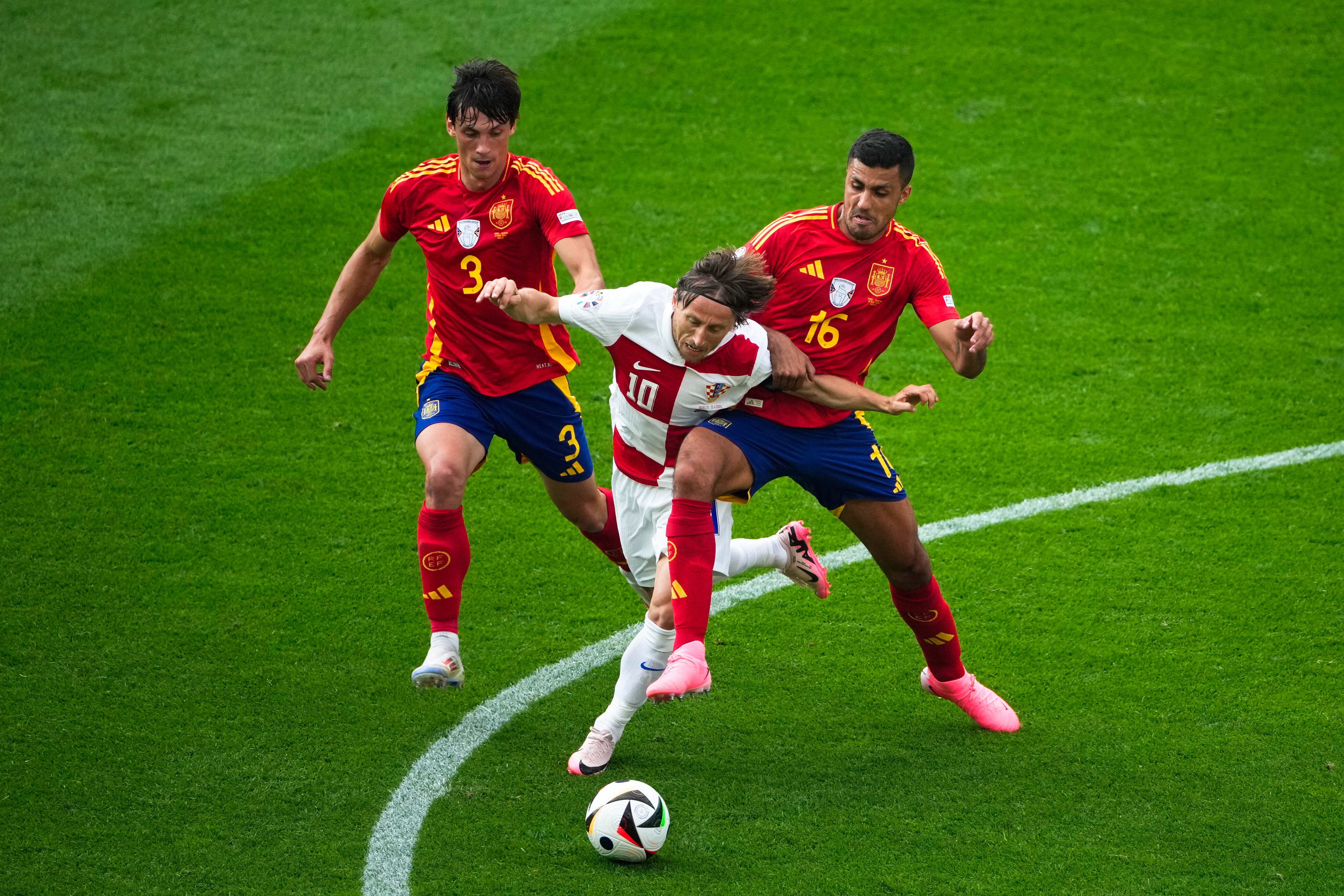 Luka Modric se lleva el balón entre Rodri y Le Normand.