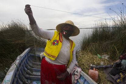 Una mujer del pueblo denominado Uros que vive en islas flotantes del lago Titicaca muestra su red de pesca. La escasez de especies ha hecho que la población local vea turismo como una alternativa.